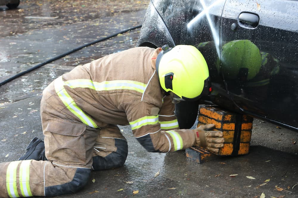 Trainee Firefighter putting a support under a vehicle