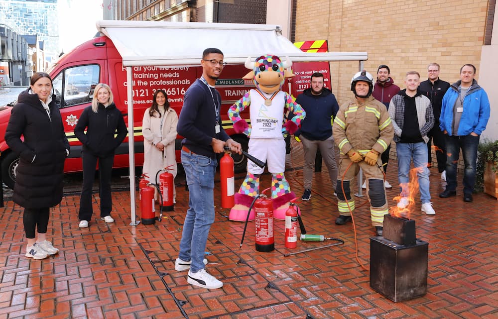Staff from the Commonwealth games being trained in using a fire extinguisher