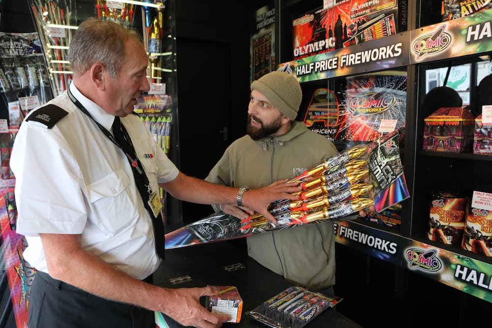 A fire safety officer talking to a fireworks shop owner