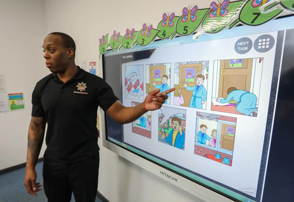 A firefighter pointing to a presentation during a school visit