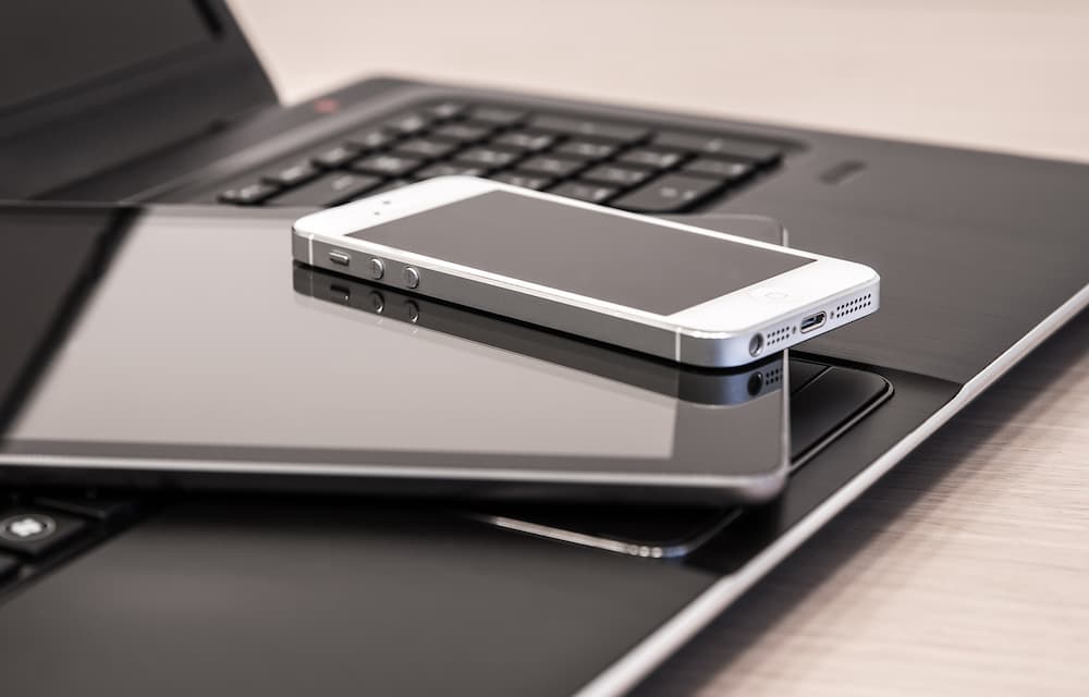 Close up of a laptop, tablet and mobile phone stacked together