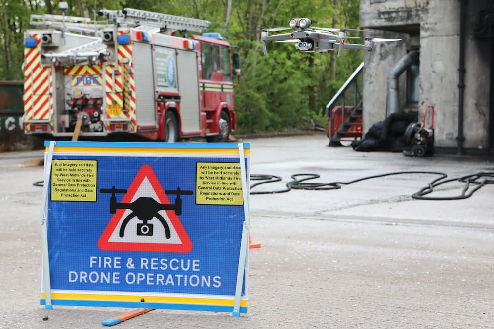 A drone flying above a sign saying 'Fire and Rescue Drone Operations'