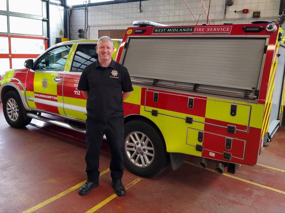 Firefighter Phil King stood in front of a brigade response vehicle