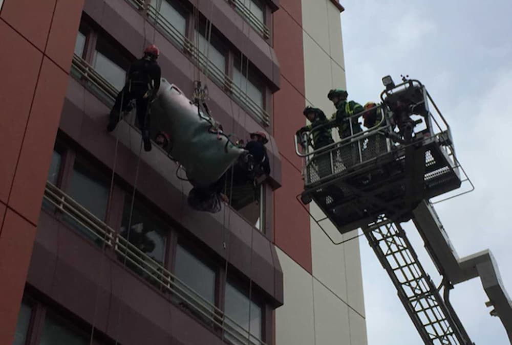 A bariatric patient being lowered with a hydraulic platform assisting