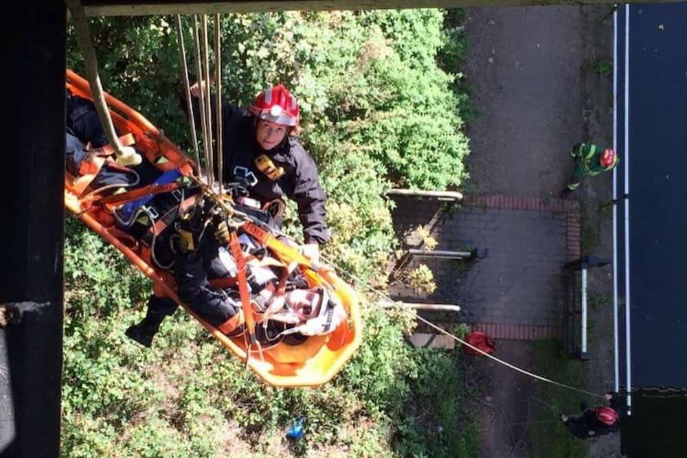 A patient being lowered in a rope rescue scenario