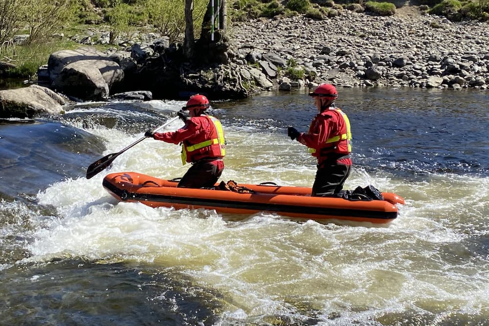 Water rescue personnel in a boat on a river