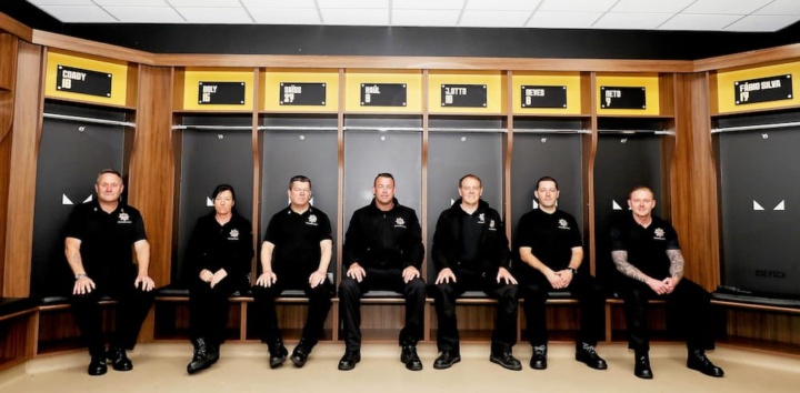 Firefighters pose in dressing room under Wolves player names