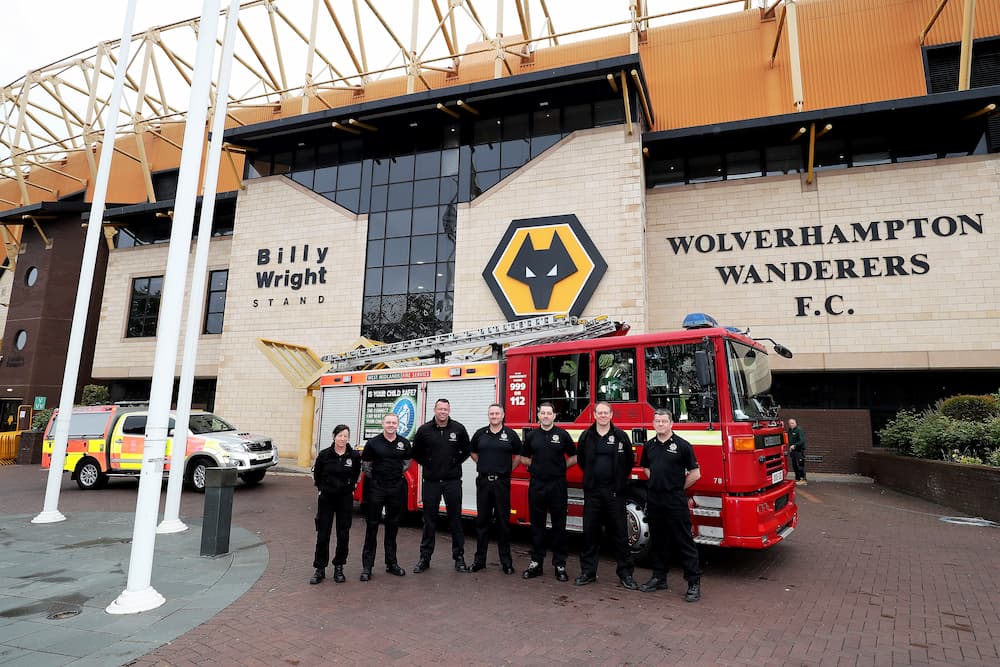 Firefighters stand in front of a fire engine outside Molineux