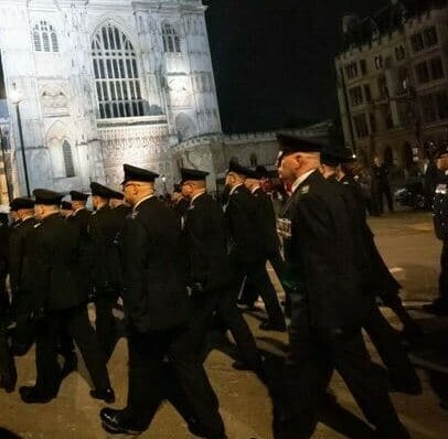 Fire and rescue service representatives march past Westminster Abbey during a night-time rehearsal for the State Funeral procession