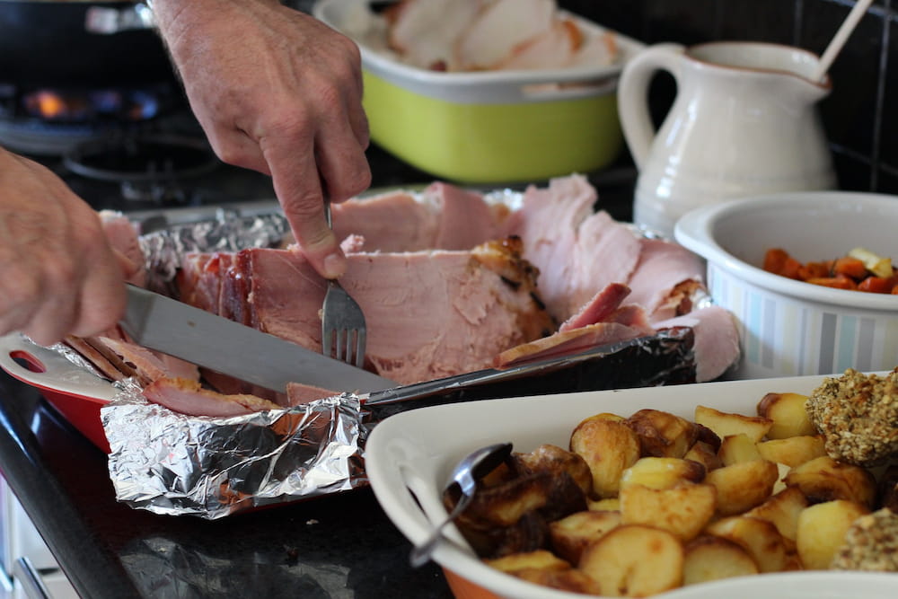 A man's hands cutting meat for a Christmas dinner