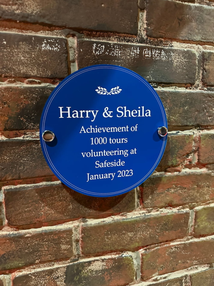 A plaque commemorating Harry and Sheila's achievement of 1000 tours volunteering at Safeside.