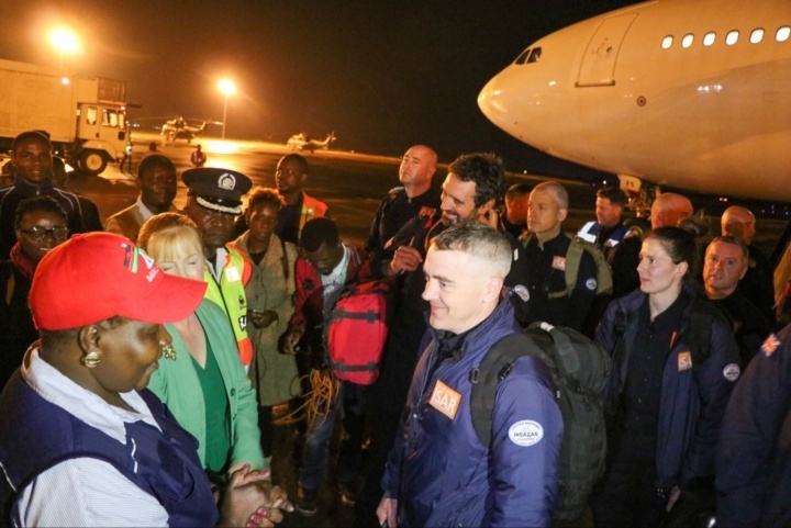 Staff from UK fire and rescue services are met by local officials near their plane