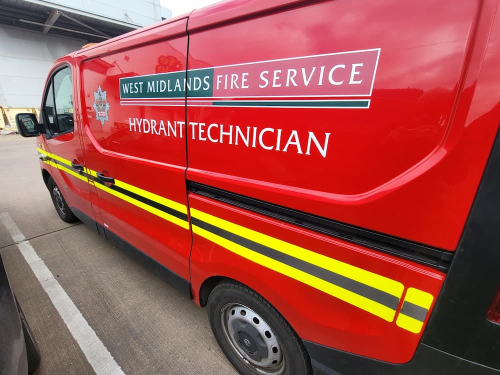 A red fire service van with Hydrant Technician and the West Midlands Fire Service logo on the side.