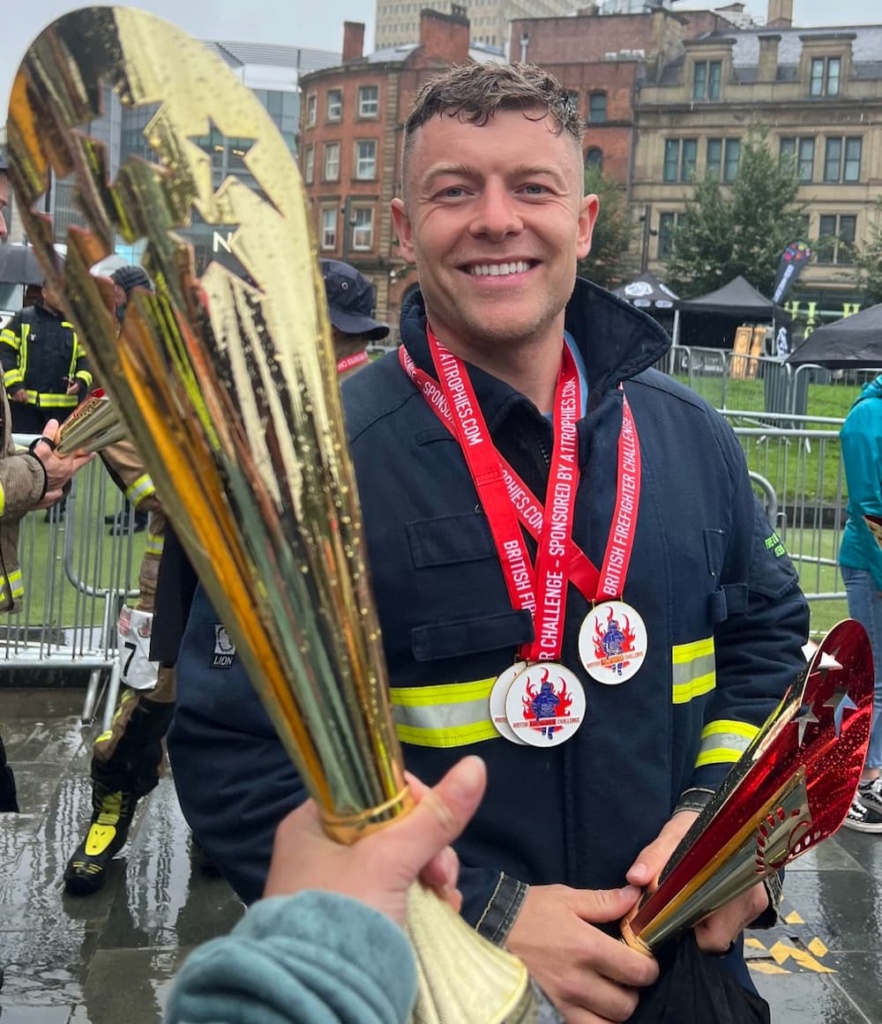 Firefighter Jack Baker smiling while being awarded a trophy