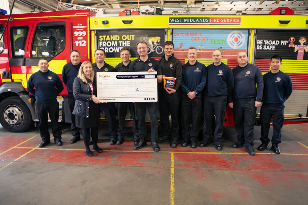 Firefighters pose with a cheque, presented to St Giles Hospice
