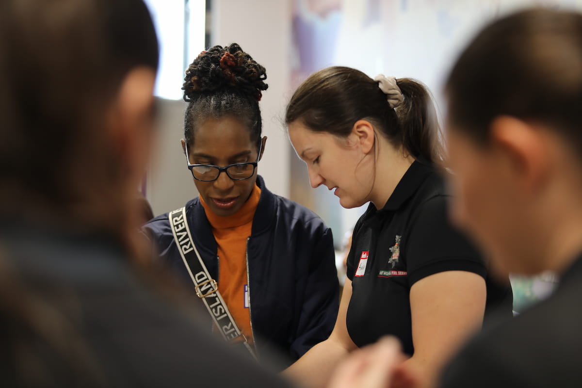 A member of staff talking to a lady at a community event.